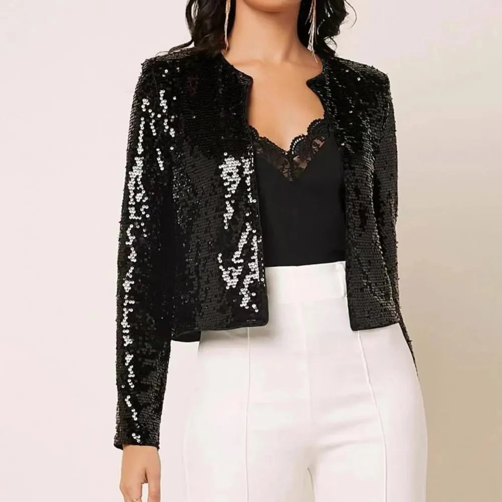 Woman wearing a black sequin cropped blazer with long sleeves and a tailored fit, suitable for formal evening wear. The blazer is paired with a champagne-colored outfit in size 2XL.