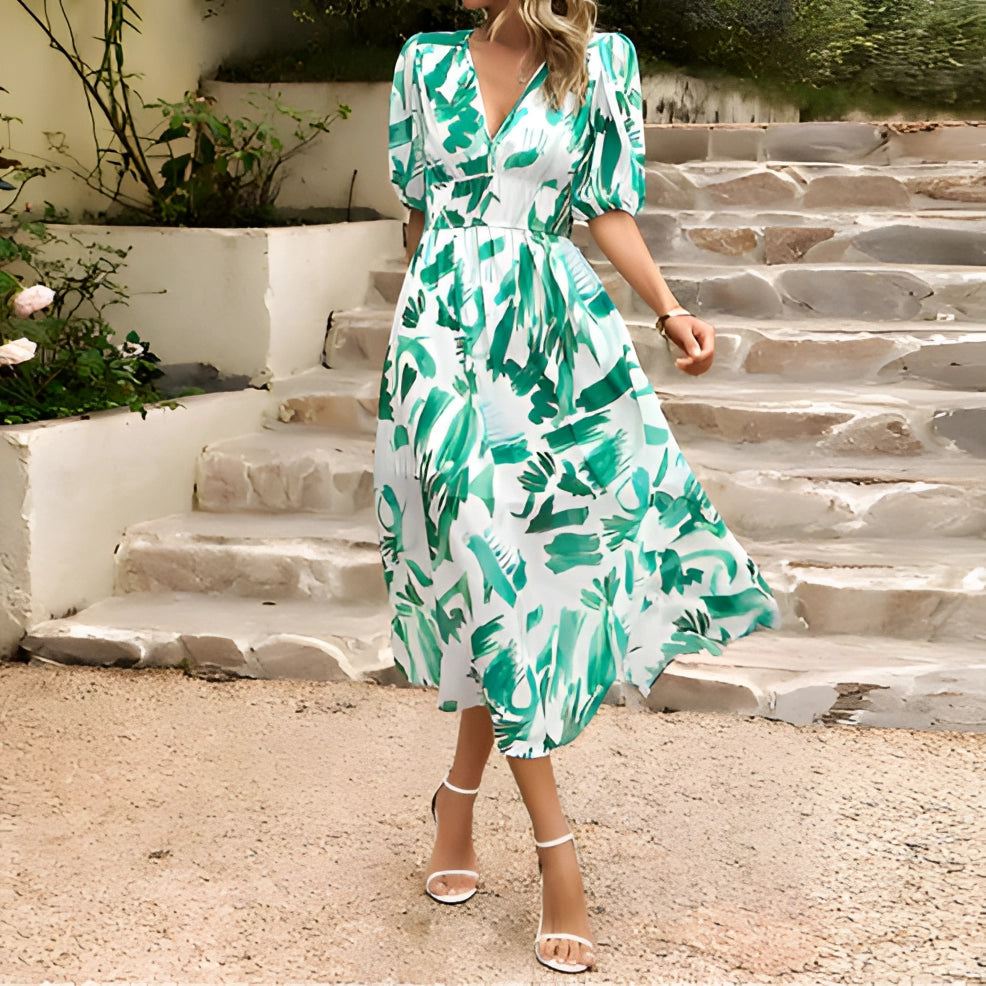 Blue tropical chiffon midi V-neck beach dress for women, displayed in green color variant size XL, featuring a one-piece design with short sleeves and a defined waist. The dress is set against a nature-inspired backdrop.