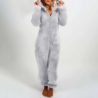 Woman wearing a light pink, 5XL, grey fleece hooded onesie, showcasing the cozy winter jumpsuit with full sleeves and a front zipper closure.