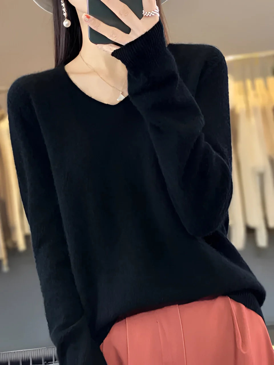 A woman wearing a luxurious emerald green cashmere sweater, showcasing its soft and elegant design.