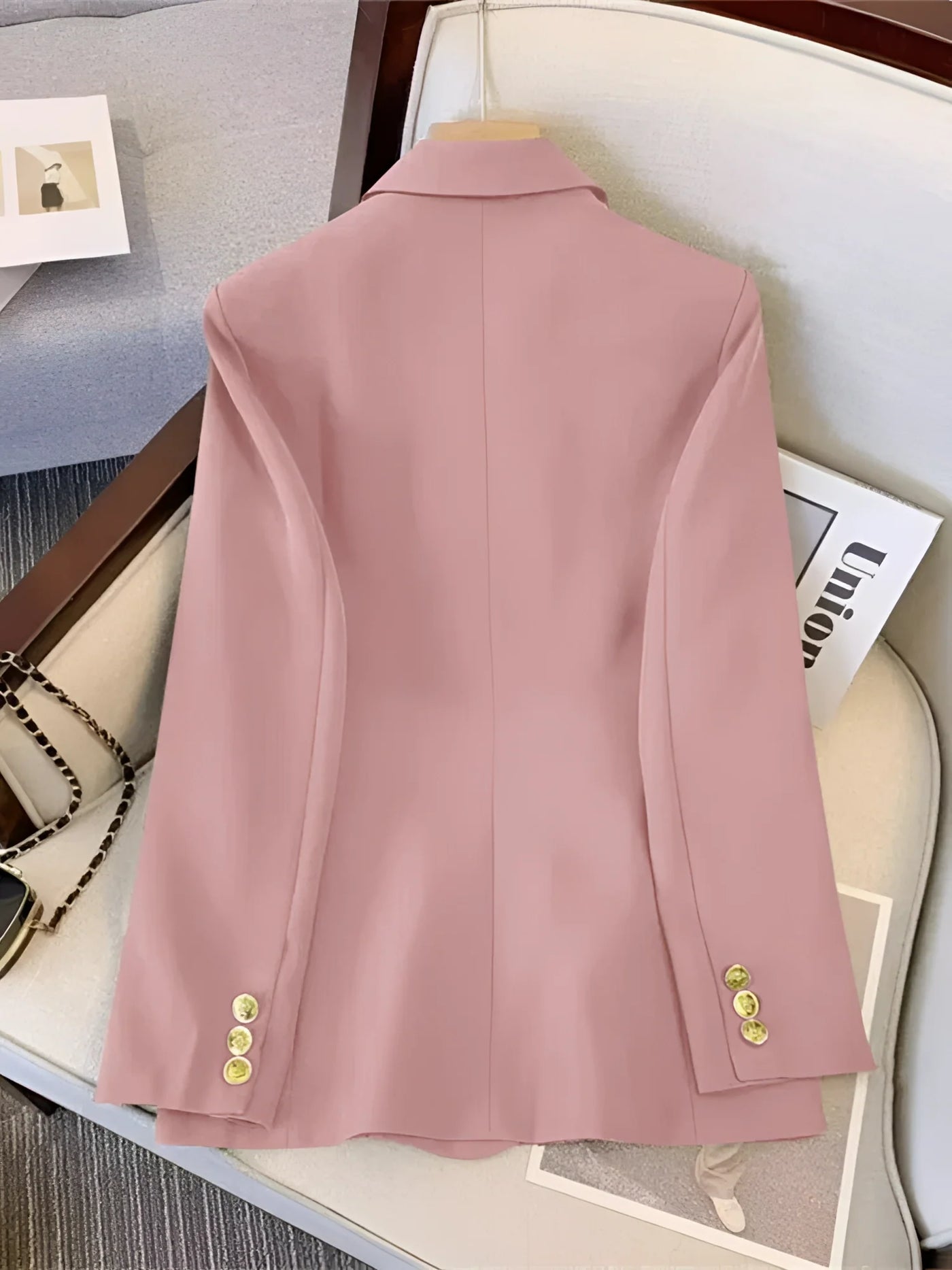 Women's elegant pink blazer with tailored double-button cuffs, featuring a collar and long sleeves.